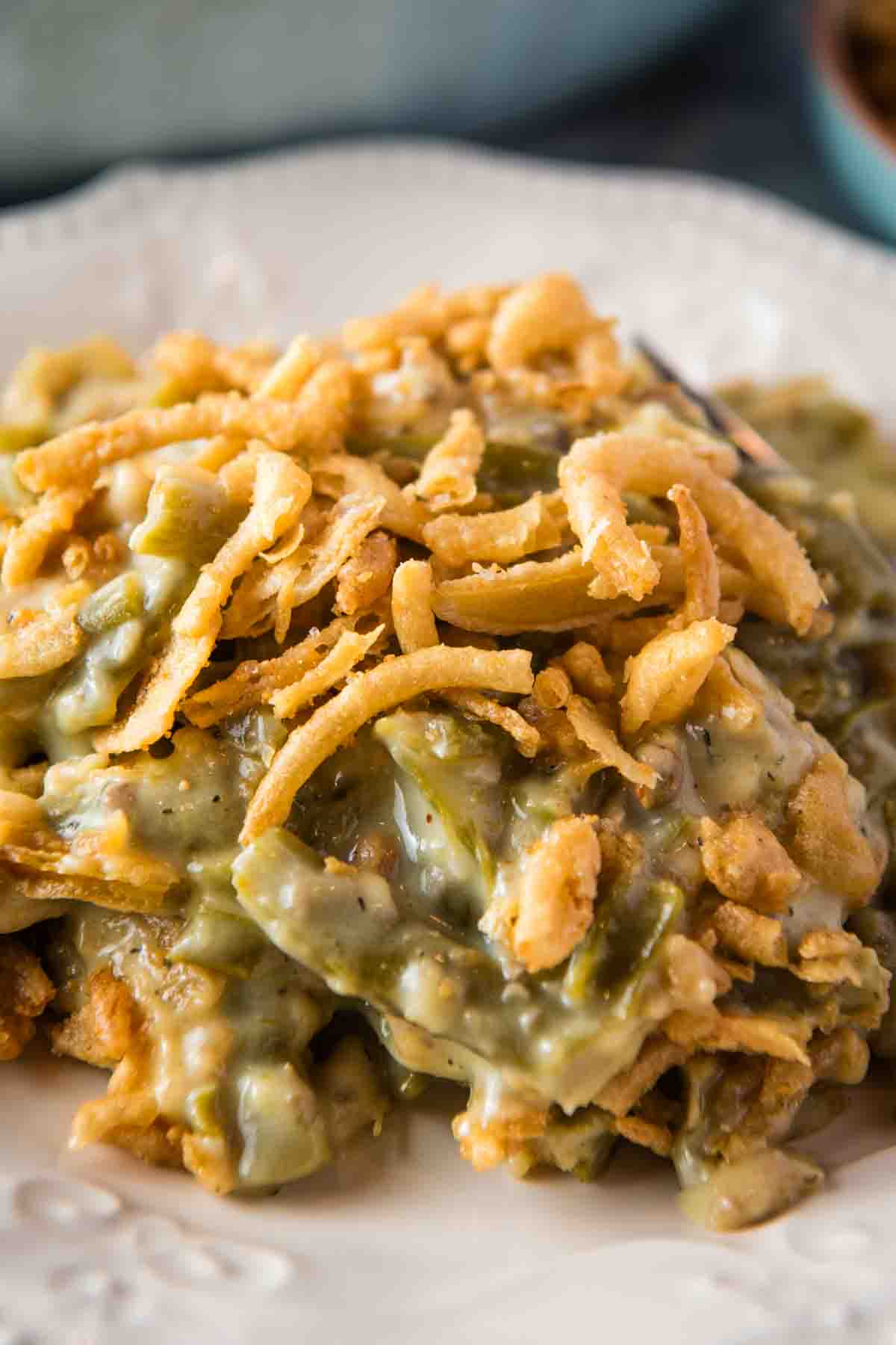 closeup photo of a pile of green bean casserole on a small white decorative plate