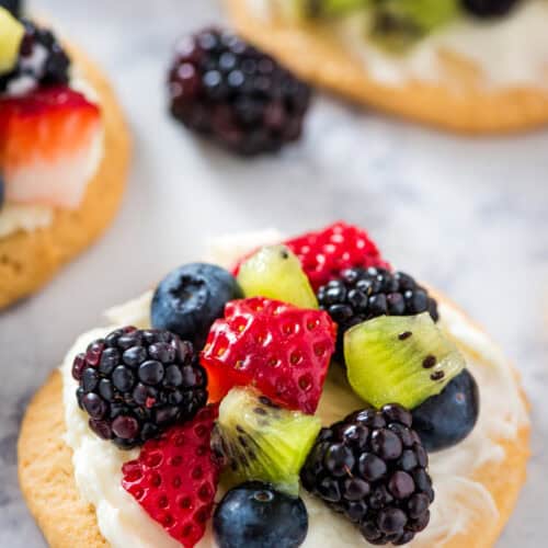 mini fruit pizzas on a marbled white countertop