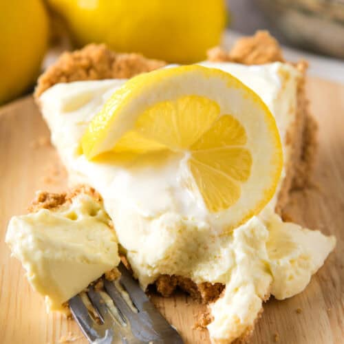lemon Dream Whip pie slice with a dollop of whipped cream and a slice of fresh lemon on top