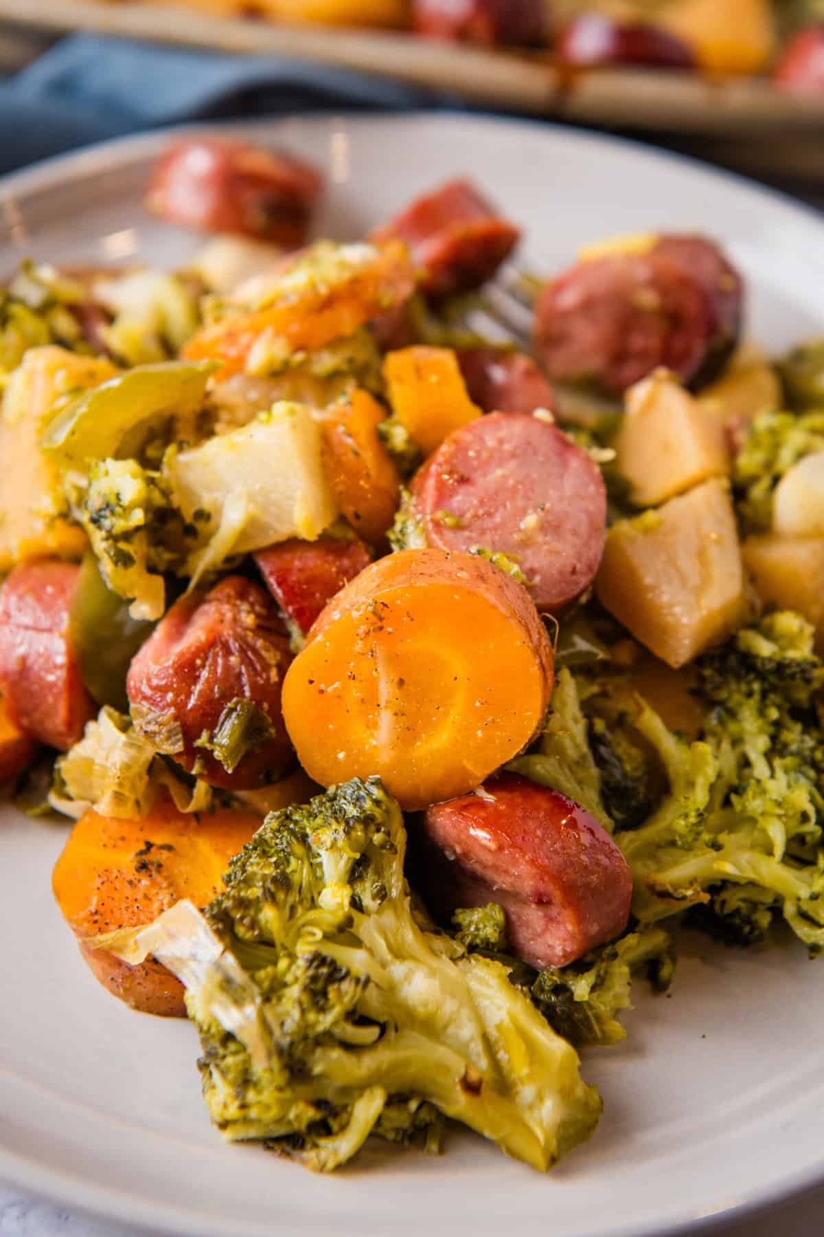 sheet pan veggies and sausage dished out and ready to serve on a small gray plate