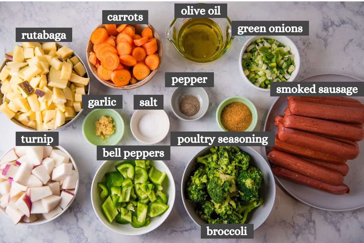 sheet pan sausage and vegetables ingredients lined out on a marbled white countertop