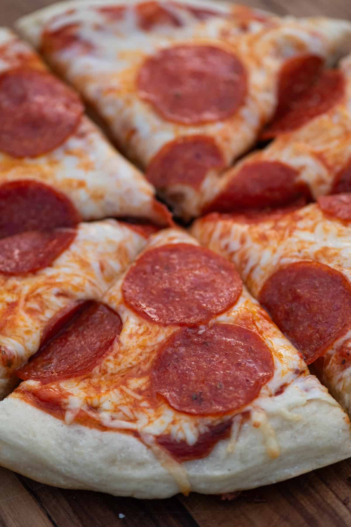 cast iron skillet pizza with pepperoni sliced up and ready to serve