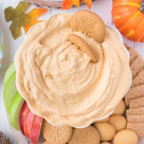 pumpkin dip in bowl with dipping cookies and apples on platter
