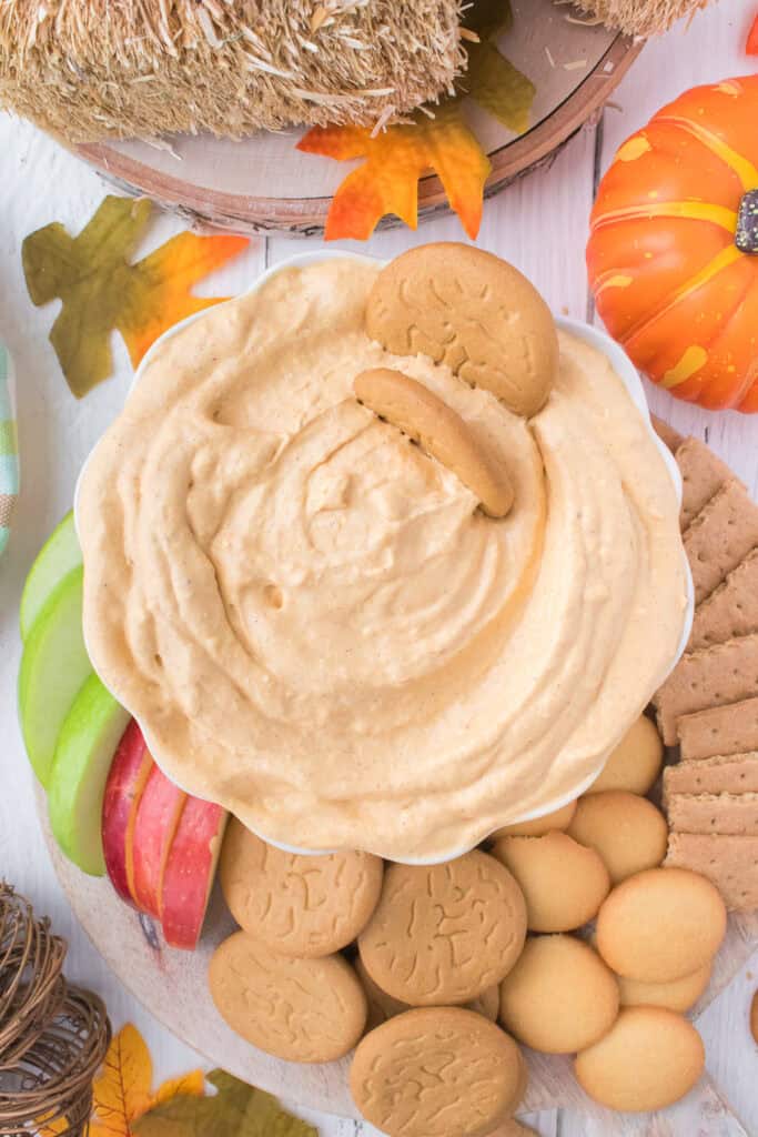 pumpkin dip in bowl with dipping cookies and apples on platter