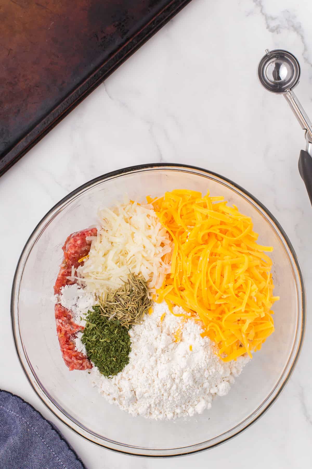 overhead shot of sausage cheese balls ingredients in a large white glass mixing bowl