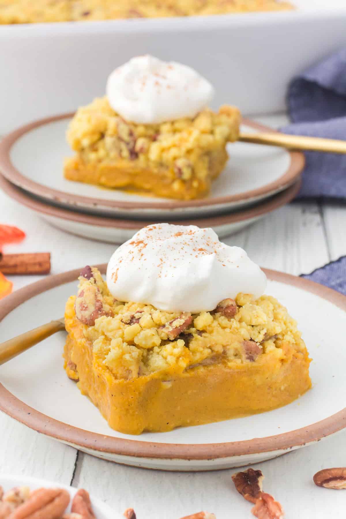 sliced pumpkin pie cake with whipped cream on brown plates