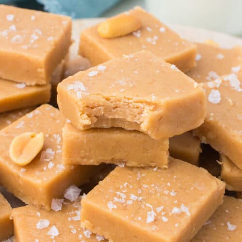 microwave peanut butter fudge with a bite taken out piled up on a white serving dish