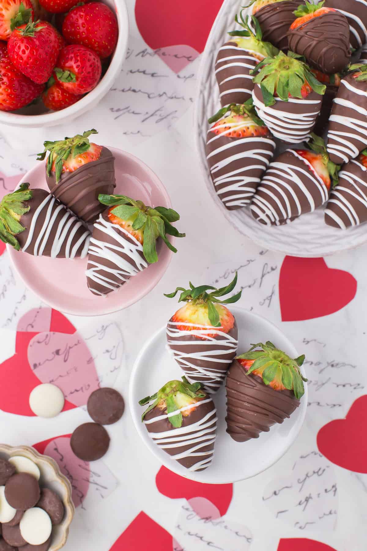 homemade chocolate covered strawberries sorted onto Valentine's Day themed serving plates