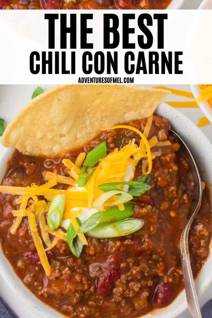 photo pin showing homemade chili con carne with a dollop of sour cream, chopped green onions and shredded cheese on top
