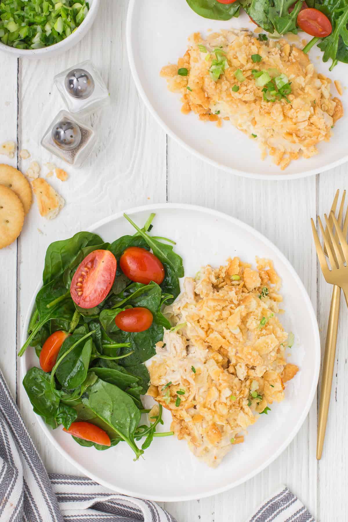 creamy Ritz chicken casserole on a small white plate with a small salad on the side
