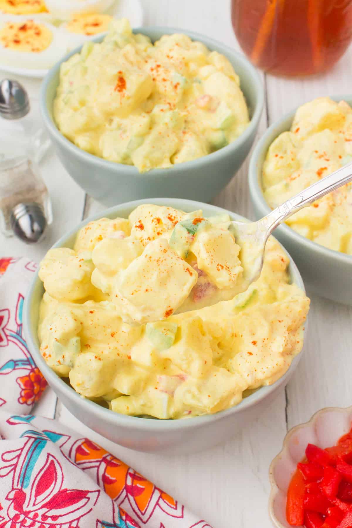 creamy deviled egg potato salad in a small gray bowl with a forkful of potato salad