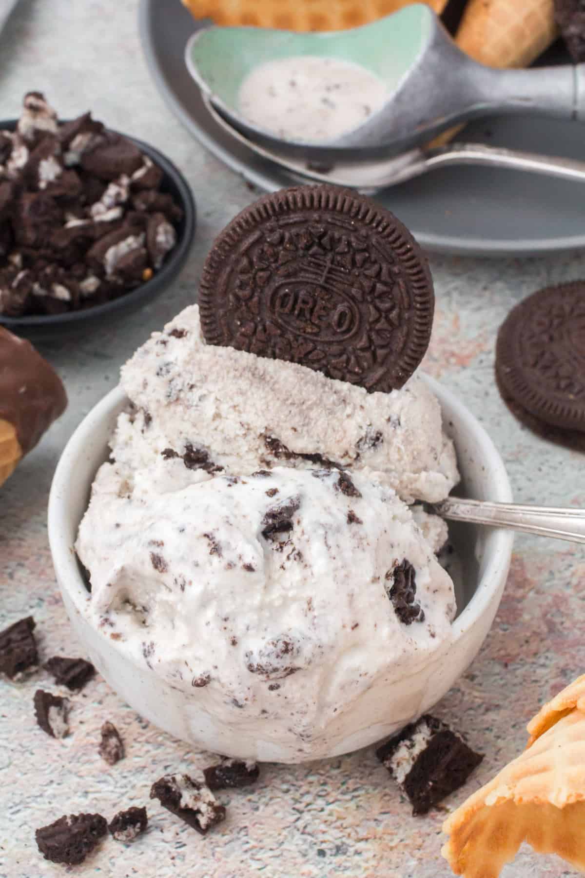 homemade cookies and cream ice cream in a small white bowl with an Oreo cookie on top