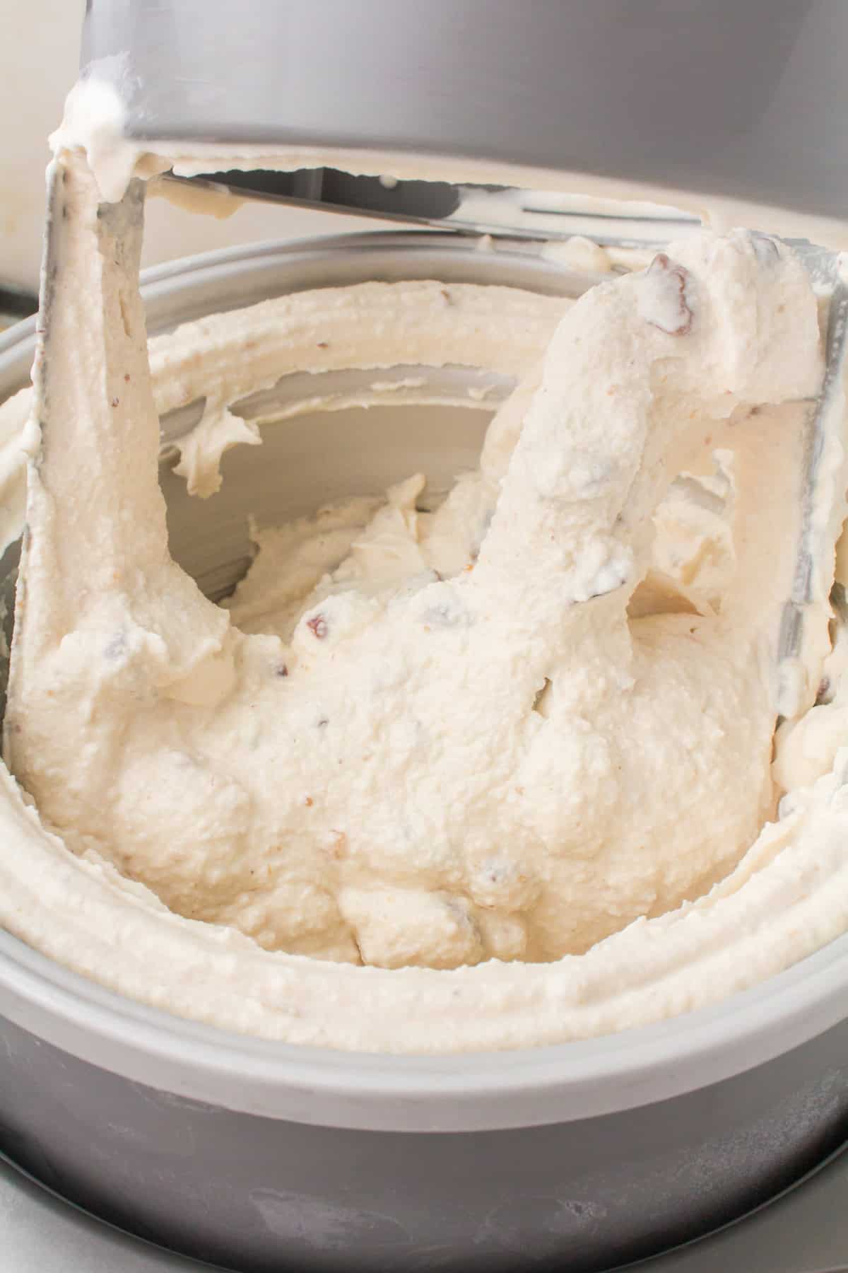 closeup shot showing an ice cream churn full of fresh homemade butter pecan ice cream