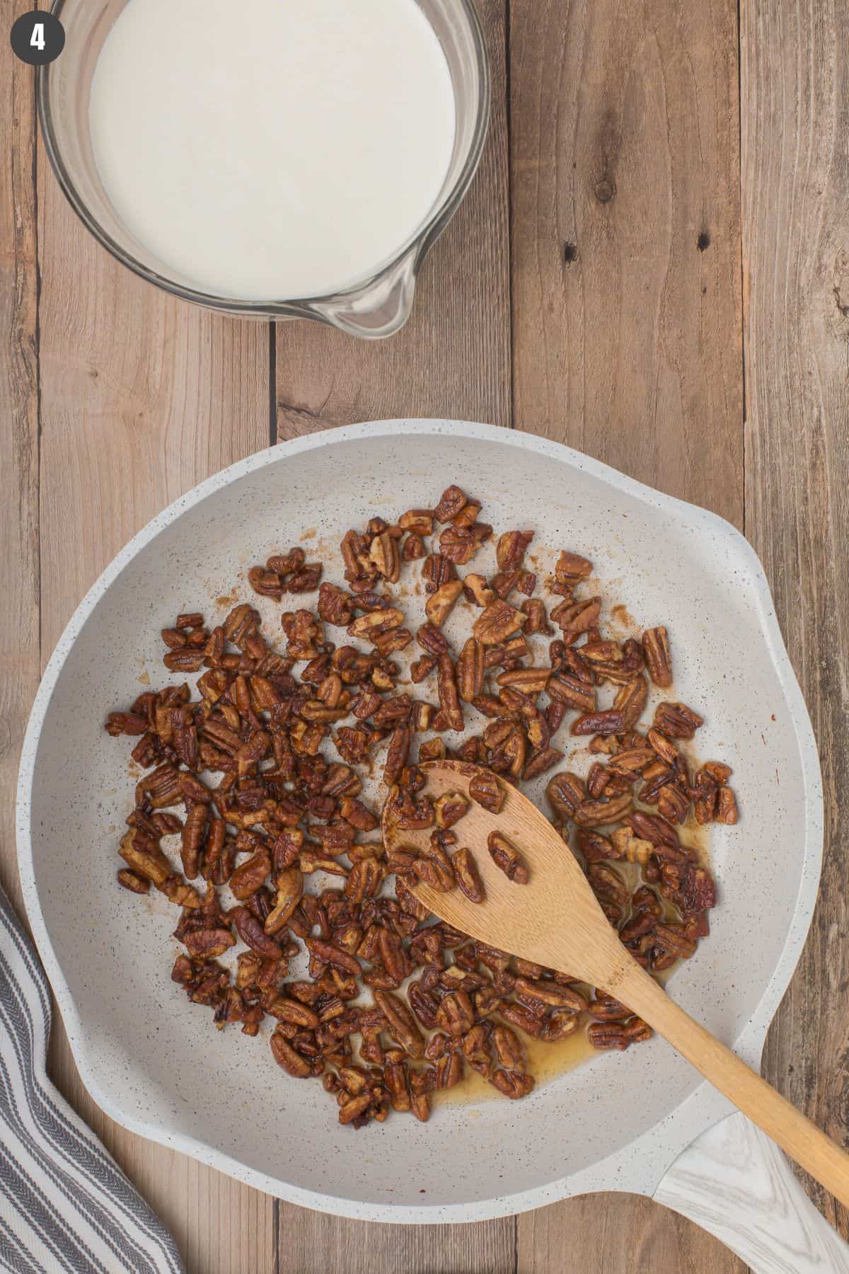 toasted pecans in a gray nonstick skillet ready to use for homemade butter pecan ice cream