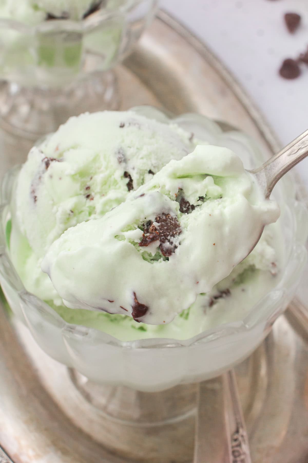 easy mint chocolate chip ice cream scooped into a small glass ramekin dish for serving