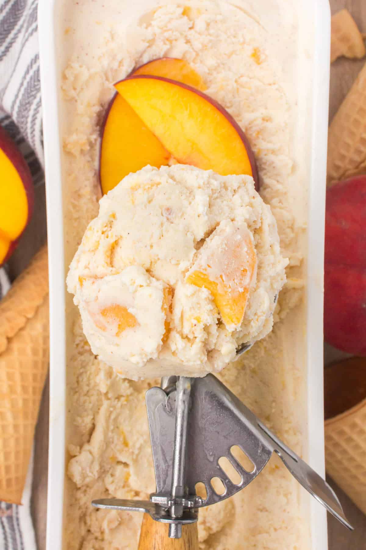 closeup shot showing a scoop of homemade peach cobbler ice cream