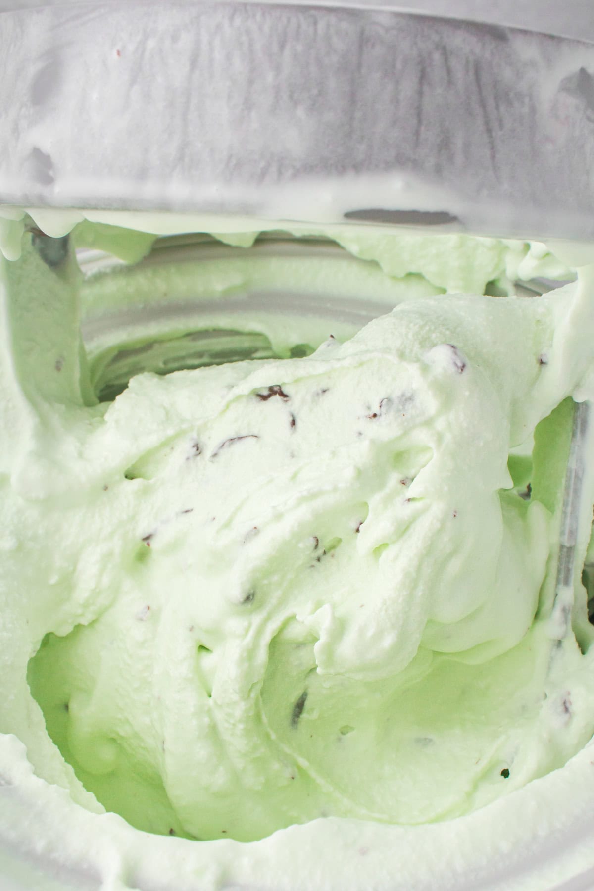closeup final shot of churned mint chocolate chip ice cream in an ice cream maker ready to serve