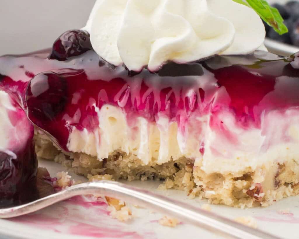 slice of blueberry delight on white plate with fork