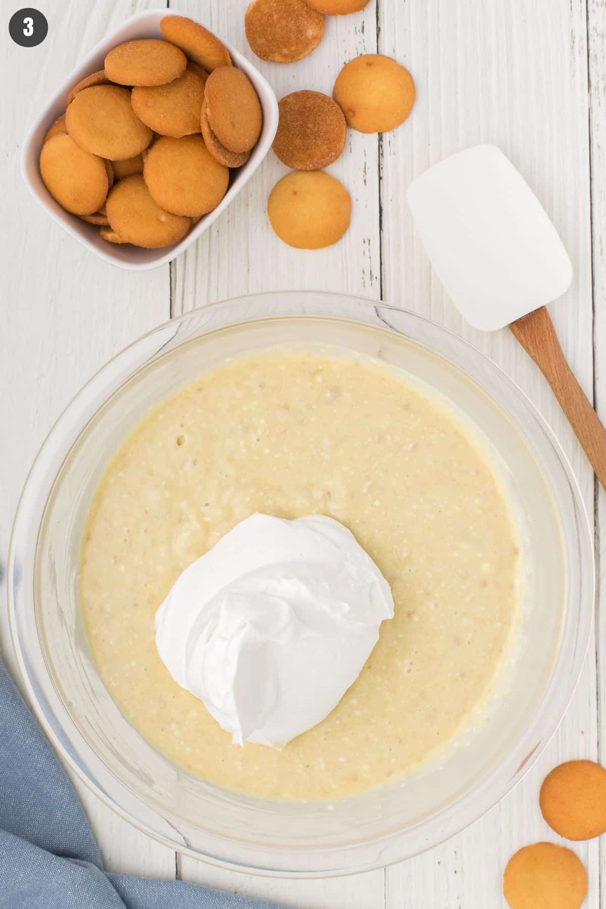 overhead shot showing the no bake banana pudding filling mixed up in a large glass mixing bowl