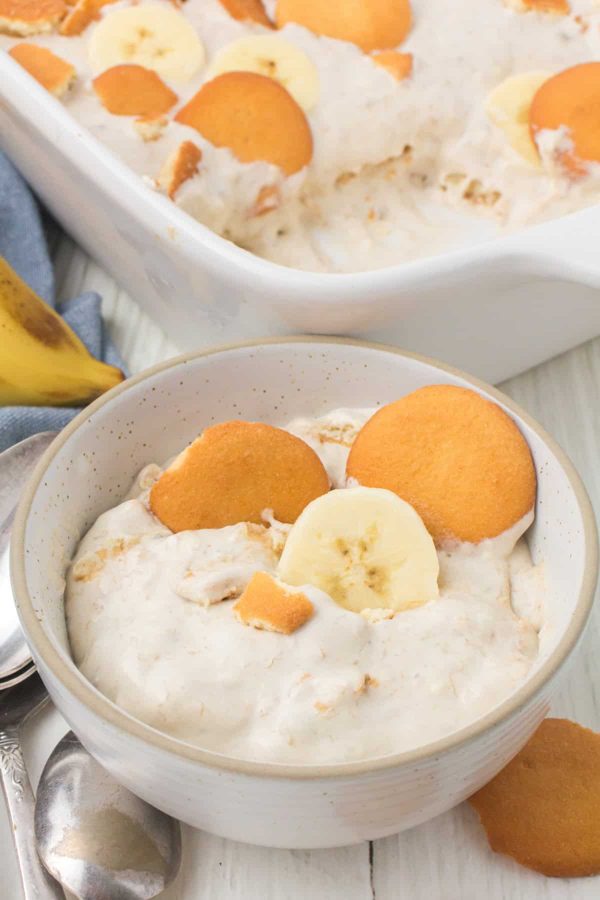 closeup shot showing a small gray bowl full of no bake banana pudding with vanilla wafers
