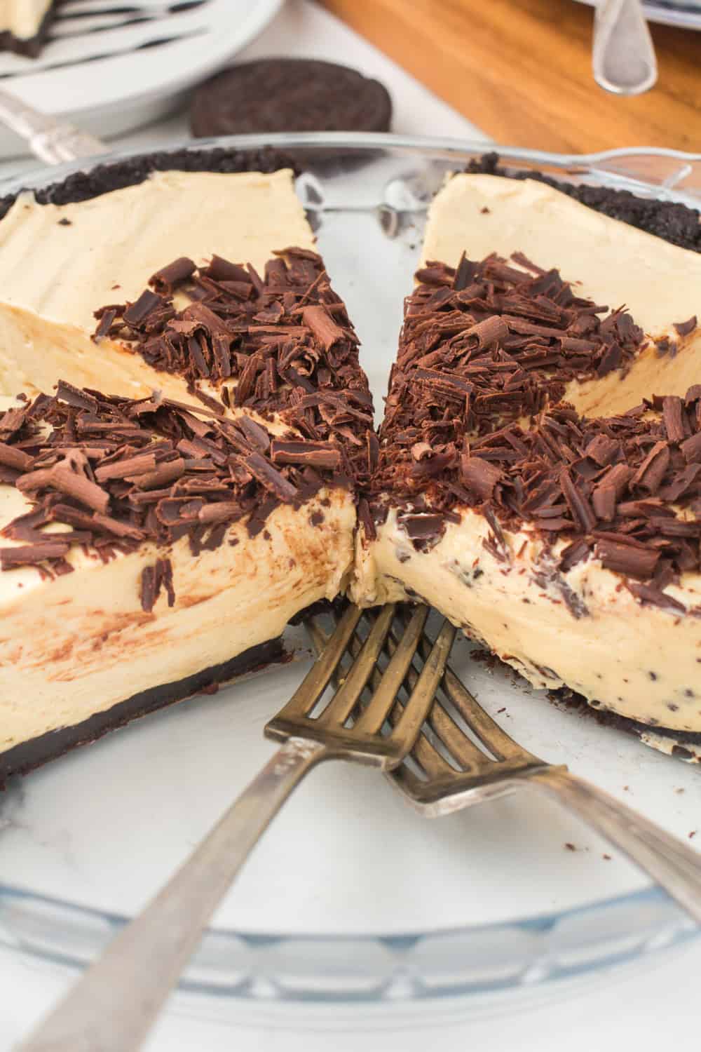 easy no bake peanut butter pie with a few slices cut out in a glass 9-inch pie plate, showing off the smooth, creamy filling