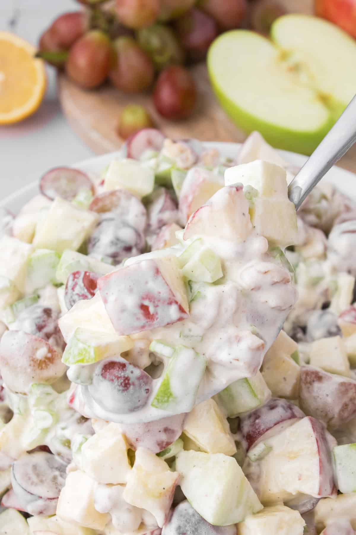 closeup shot showing a heaping spoonful of Waldorf salad with whipped cream & mayo